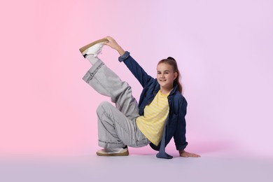Photo of Girl in stylish clothes dancing on color background