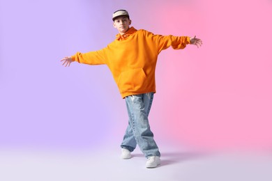 Photo of Boy in stylish clothes dancing on color background