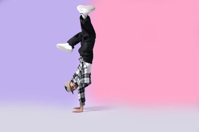 Photo of Boy in stylish clothes dancing on color background, space for text