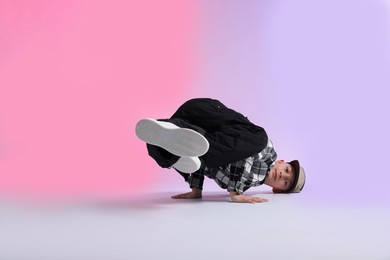 Photo of Boy in stylish clothes dancing on color background