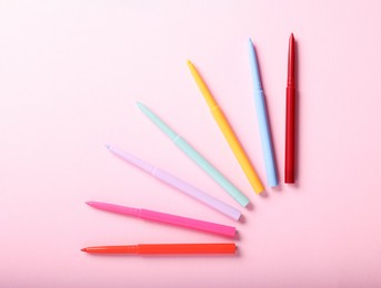 Photo of Colorful twist up eye pencils on pink background, flat lay