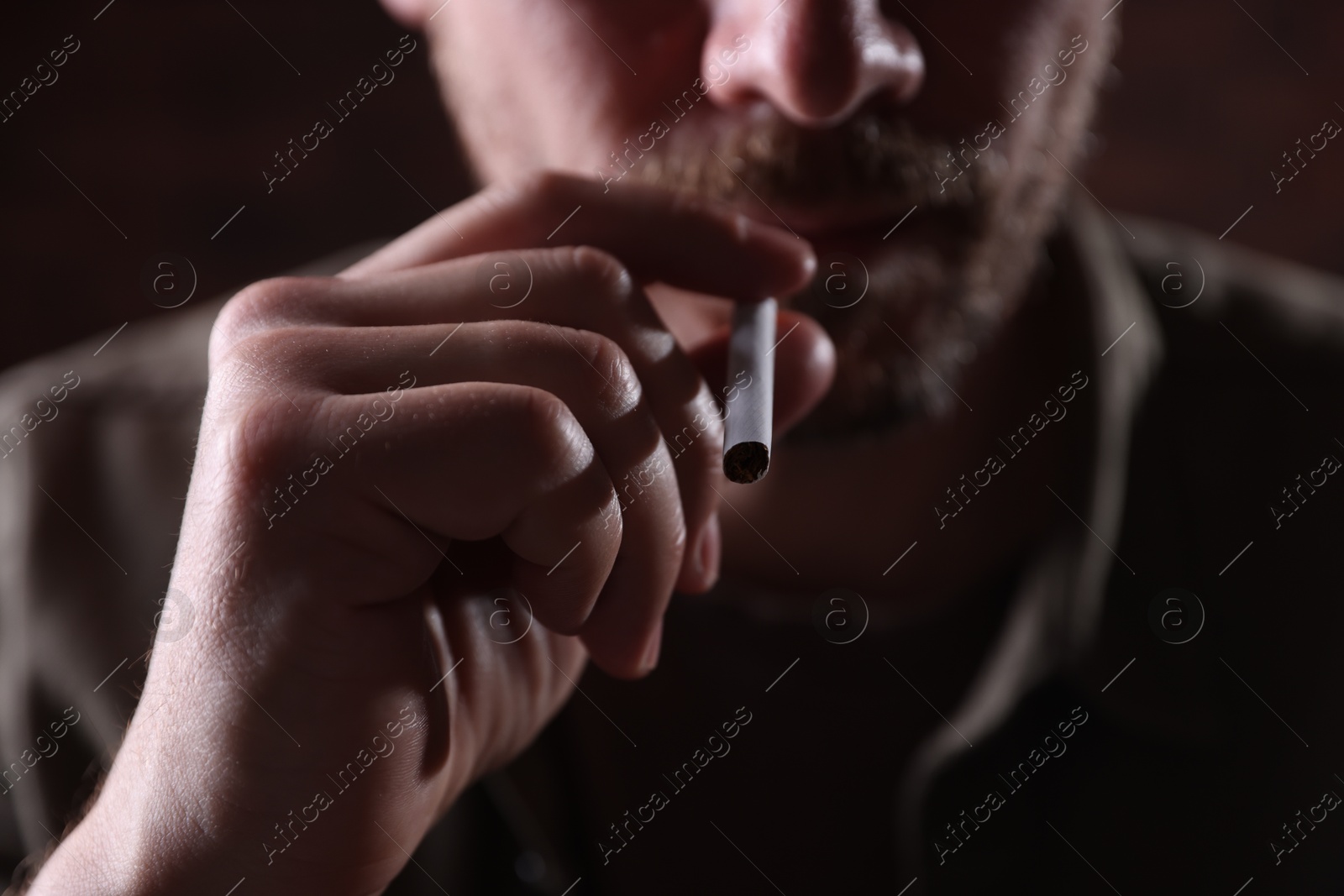 Man smoking cigarette on blurred background, closeup Photo of Man smoking cigarette on blurred background, closeup