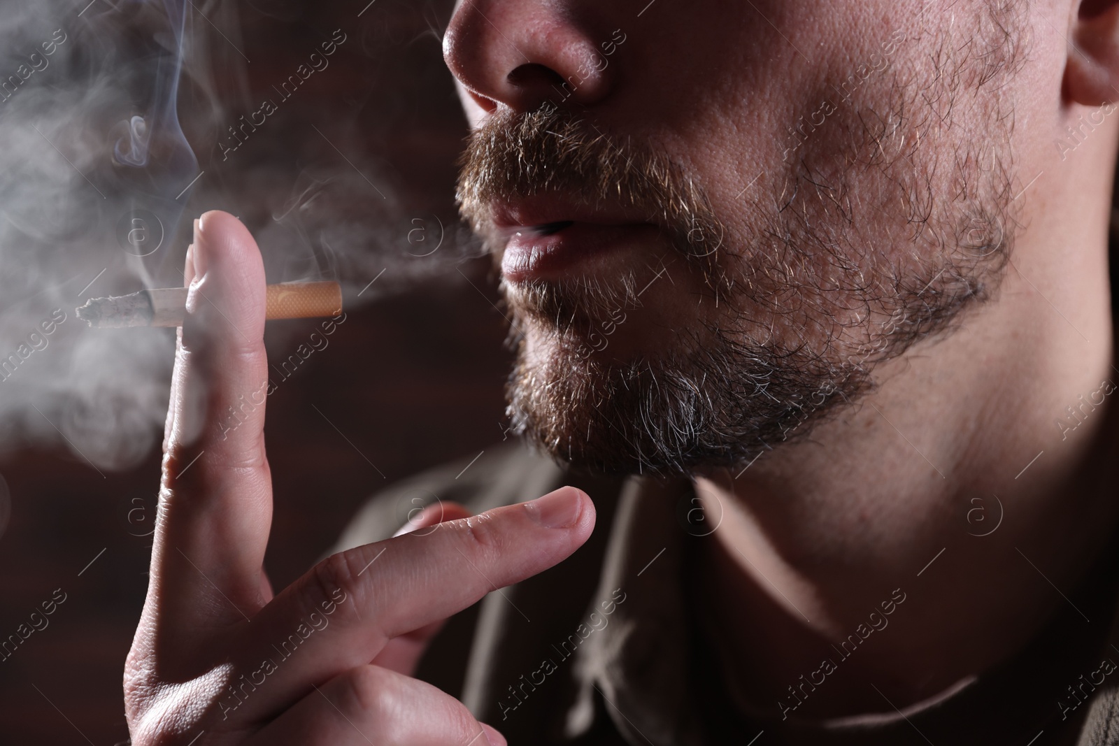 Man smoking cigarette on blurred background, closeup Photo of Man smoking cigarette on blurred background, closeup