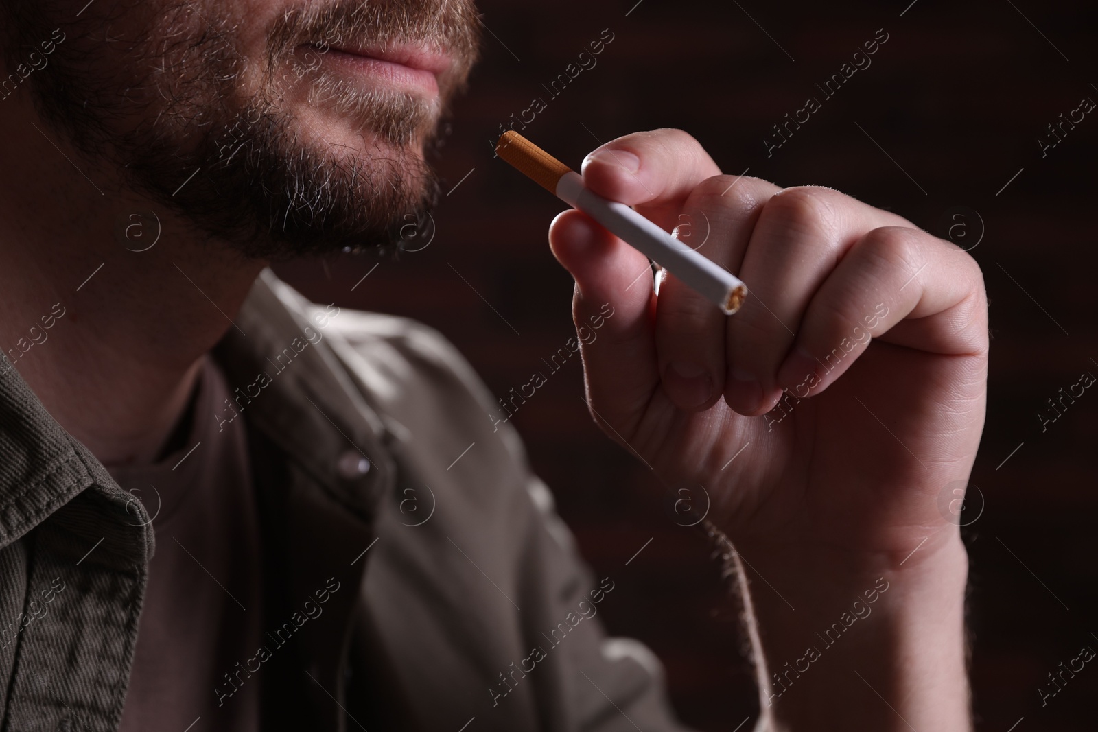 Man with cigarette on blurred background, closeup. Smoking Photo of Man with cigarette on blurred background, closeup. Smoking