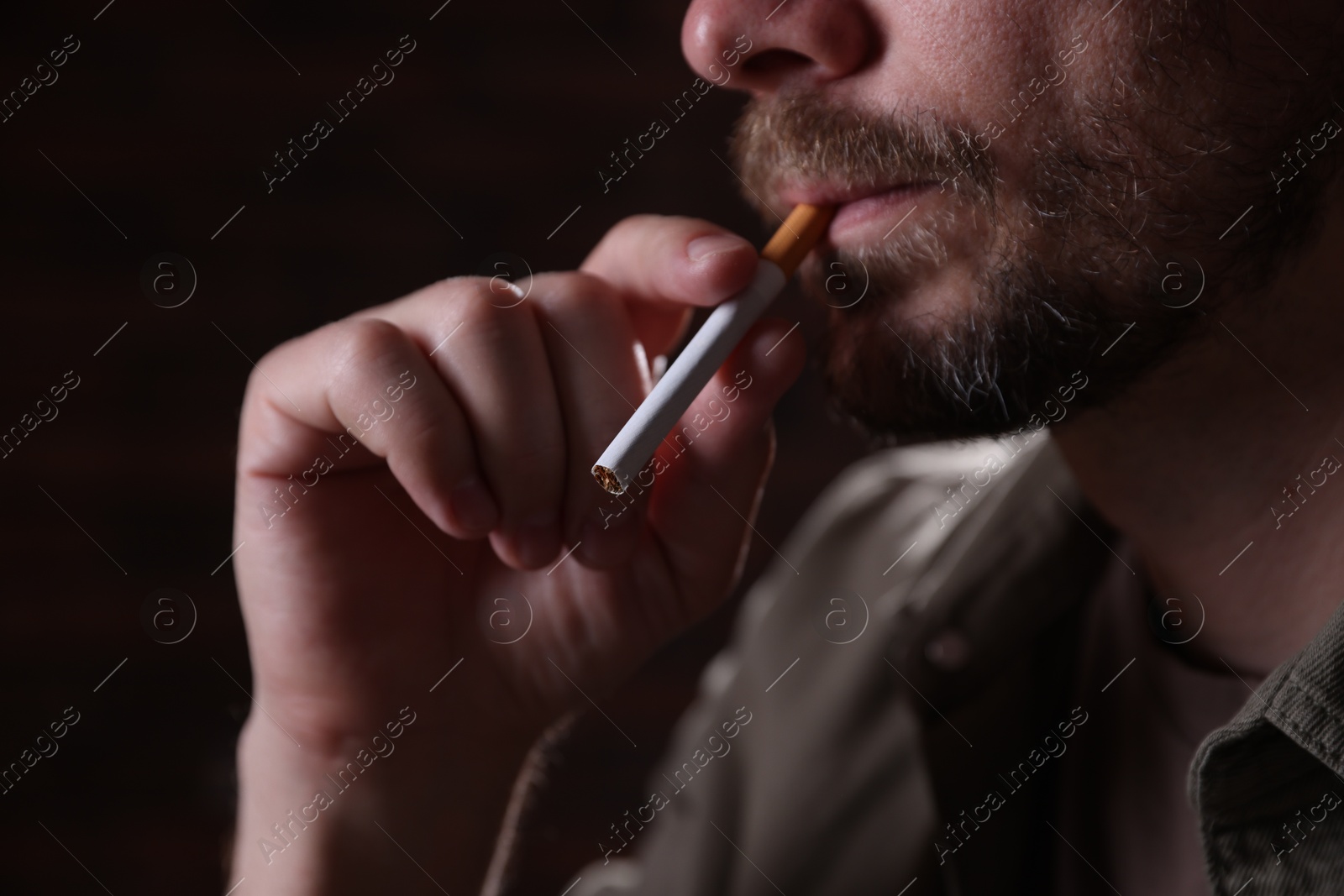 Man smoking cigarette on blurred background, closeup Photo of Man smoking cigarette on blurred background, closeup