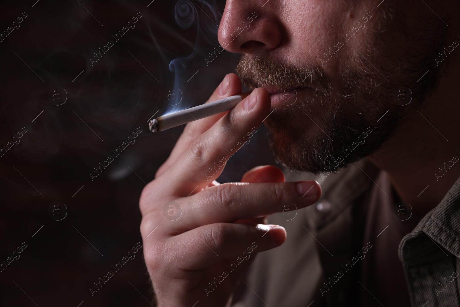 Man smoking cigarette on blurred background, closeup Photo of Man smoking cigarette on blurred background, closeup