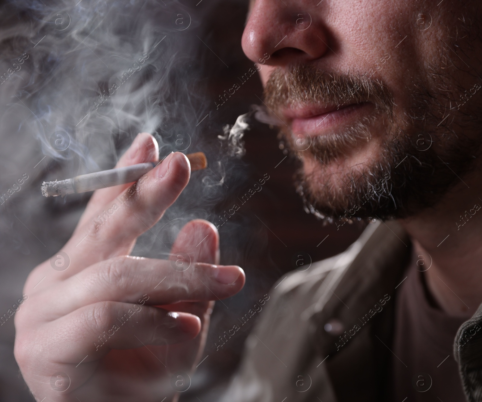 Man smoking cigarette on blurred background, closeup Photo of Man smoking cigarette on blurred background, closeup