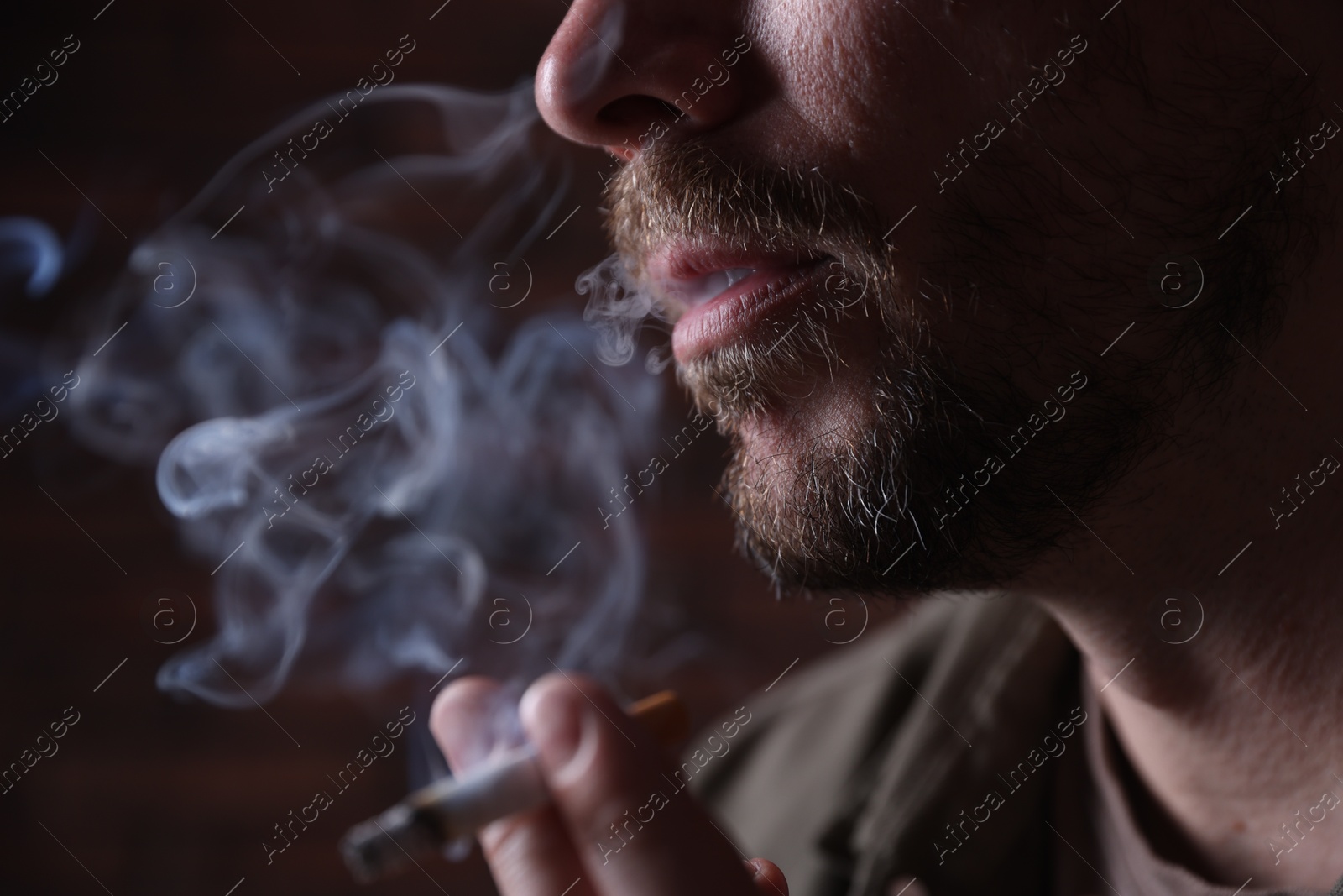 Man smoking cigarette on blurred background, closeup Photo of Man smoking cigarette on blurred background, closeup
