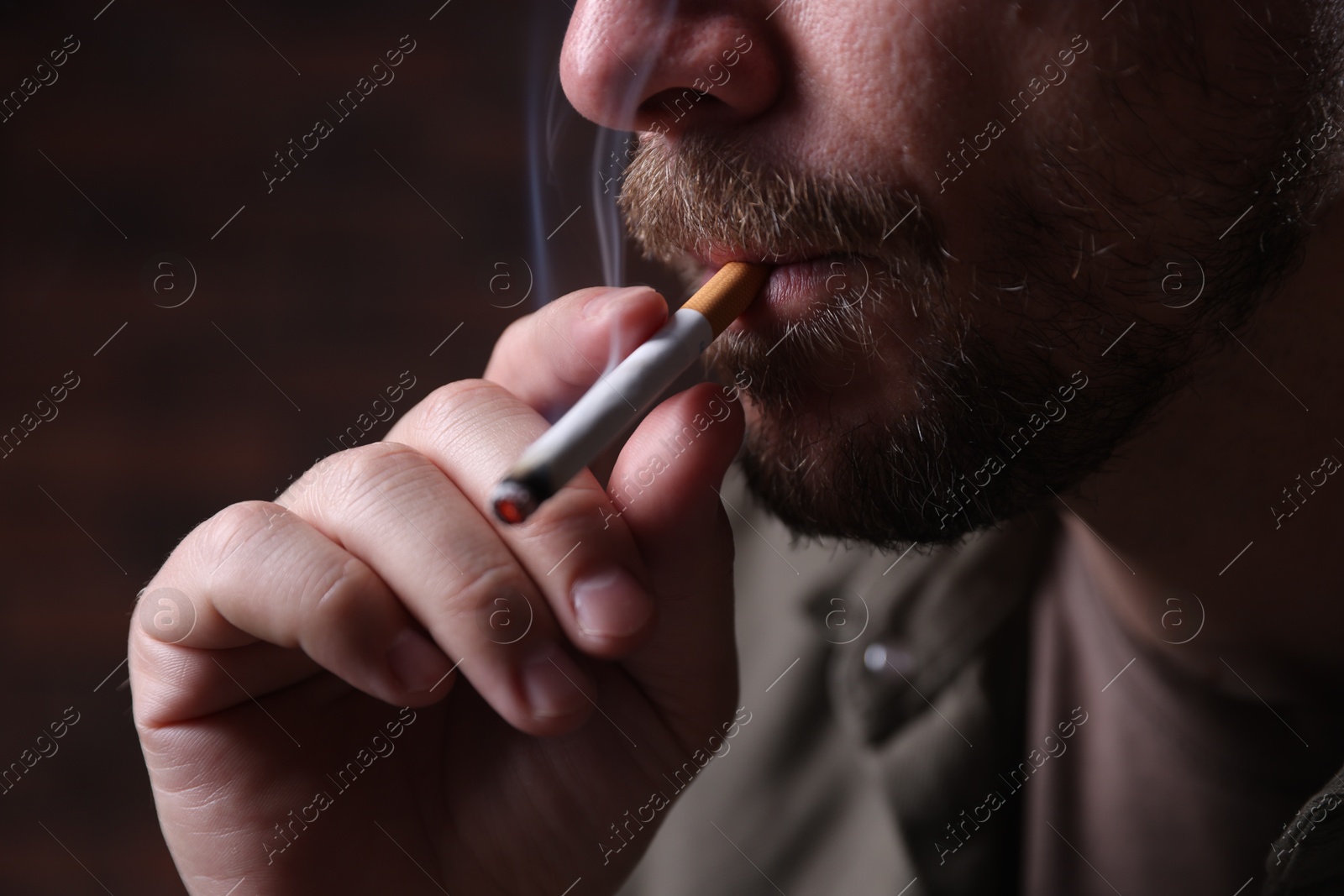 Man smoking cigarette on blurred background, closeup Photo of Man smoking cigarette on blurred background, closeup