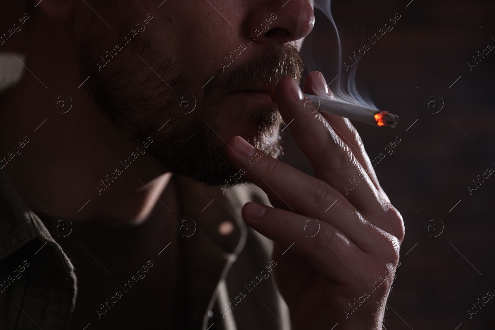 Man smoking cigarette on blurred background, closeup Photo of Man smoking cigarette on blurred background, closeup