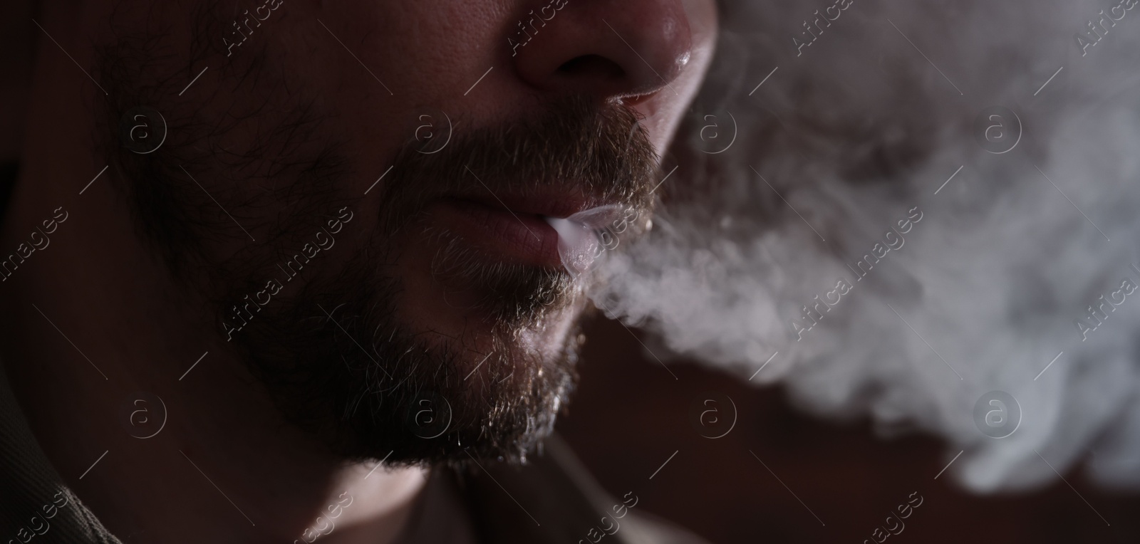 Man smoking on blurred background, closeup view Photo of Man smoking on blurred background, closeup view