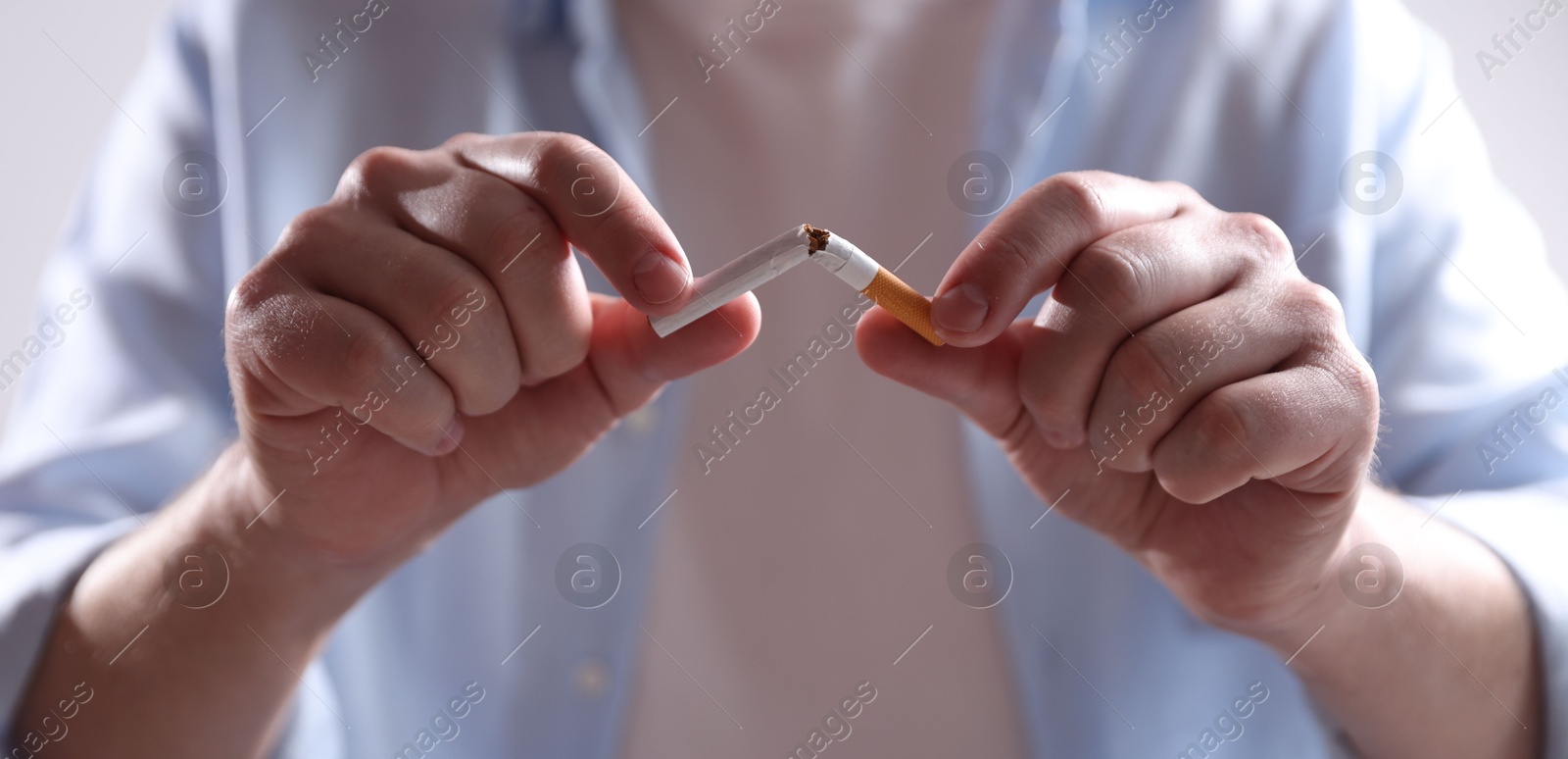 Man holding broken cigarette, closeup. Stop smoking Photo of Man holding broken cigarette, closeup. Stop smoking