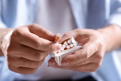 Photo of Man taking cigarette out of pack, closeup. Smoking