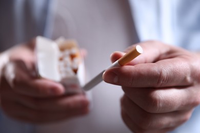 Photo of Man taking cigarette out of pack, closeup. Smoking