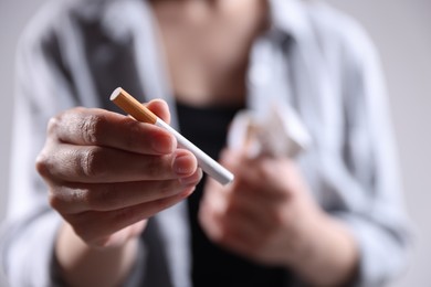 Photo of Woman with cigarette on light background, closeup. Smoking