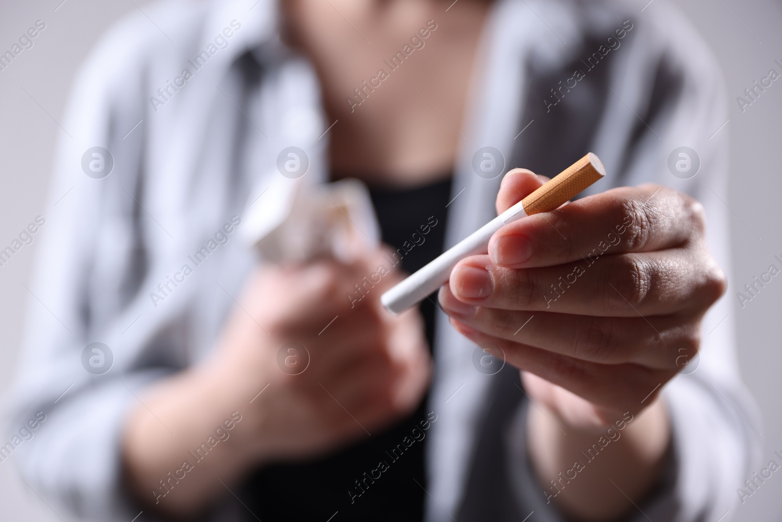 Woman with cigarette on light background, closeup. Smoking Photo of Woman with cigarette on light background, closeup. Smoking