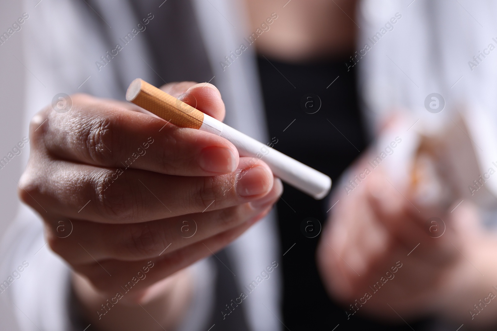 Woman with cigarette on light background, closeup. Smoking Photo of Woman with cigarette on light background, closeup. Smoking