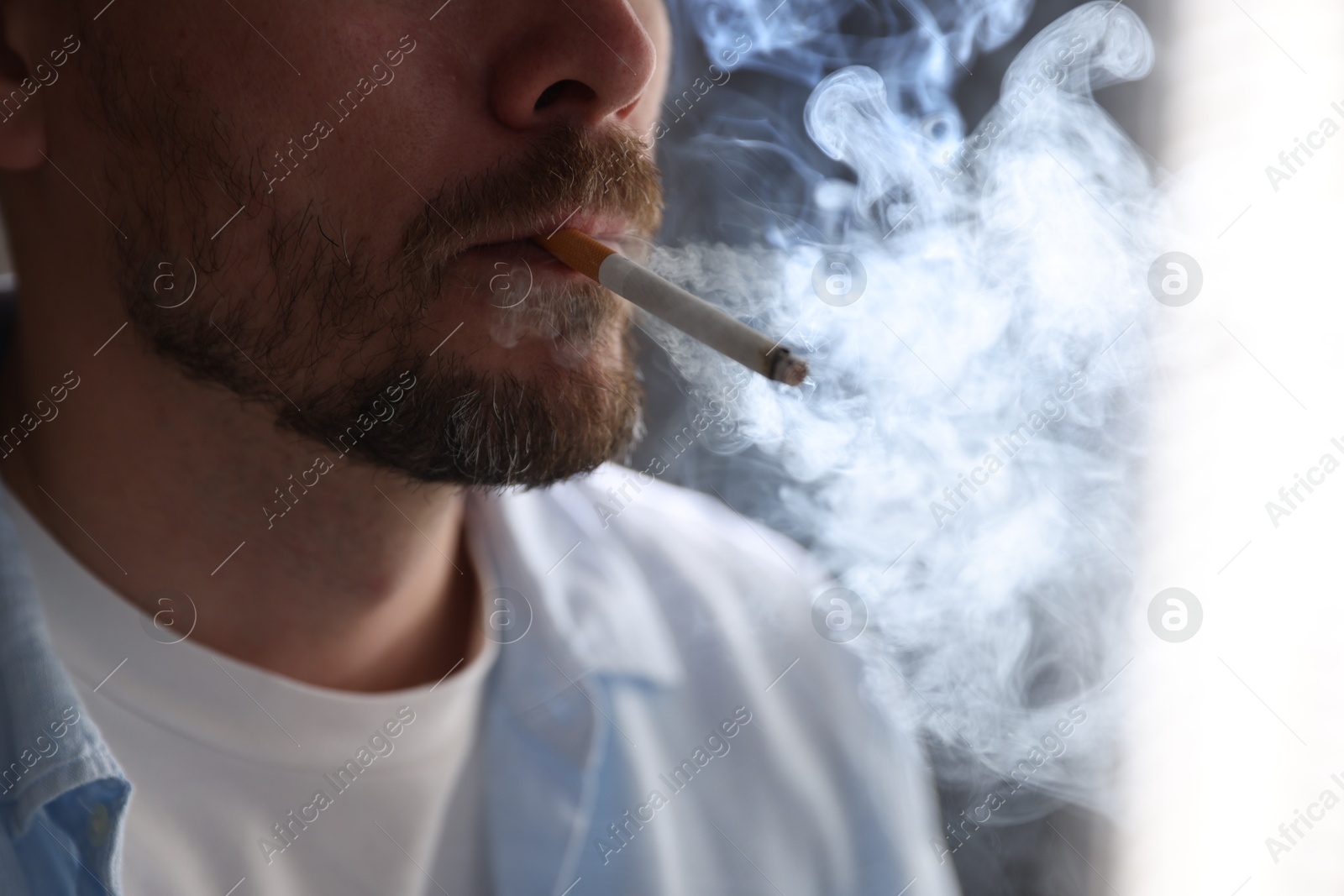 Man smoking cigarette on blurred background, closeup Photo of Man smoking cigarette on blurred background, closeup