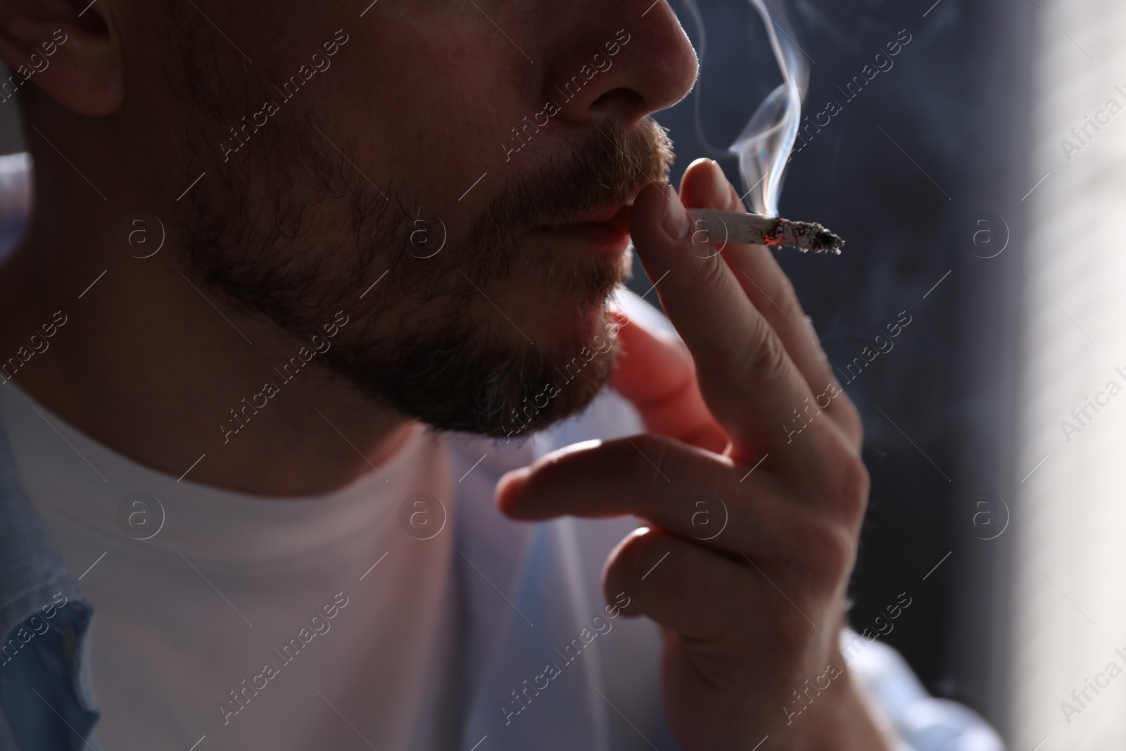 Man smoking cigarette on blurred background, closeup Photo of Man smoking cigarette on blurred background, closeup