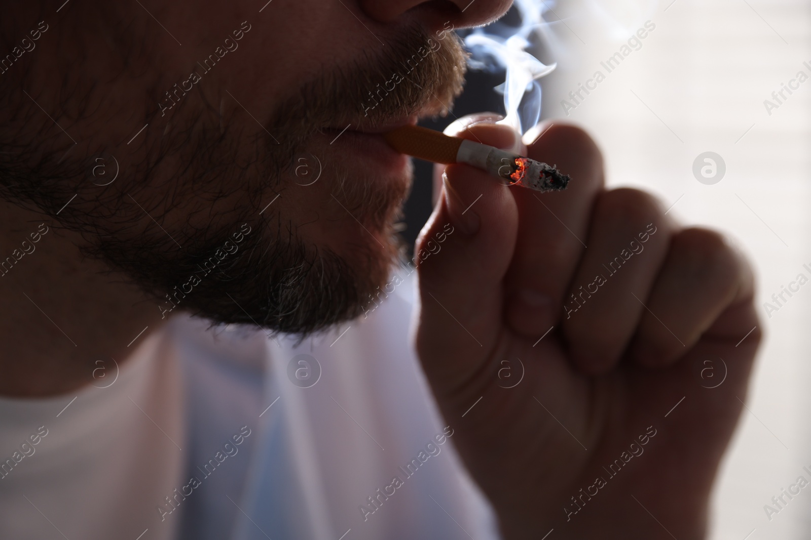 Man smoking cigarette on blurred background, closeup Photo of Man smoking cigarette on blurred background, closeup