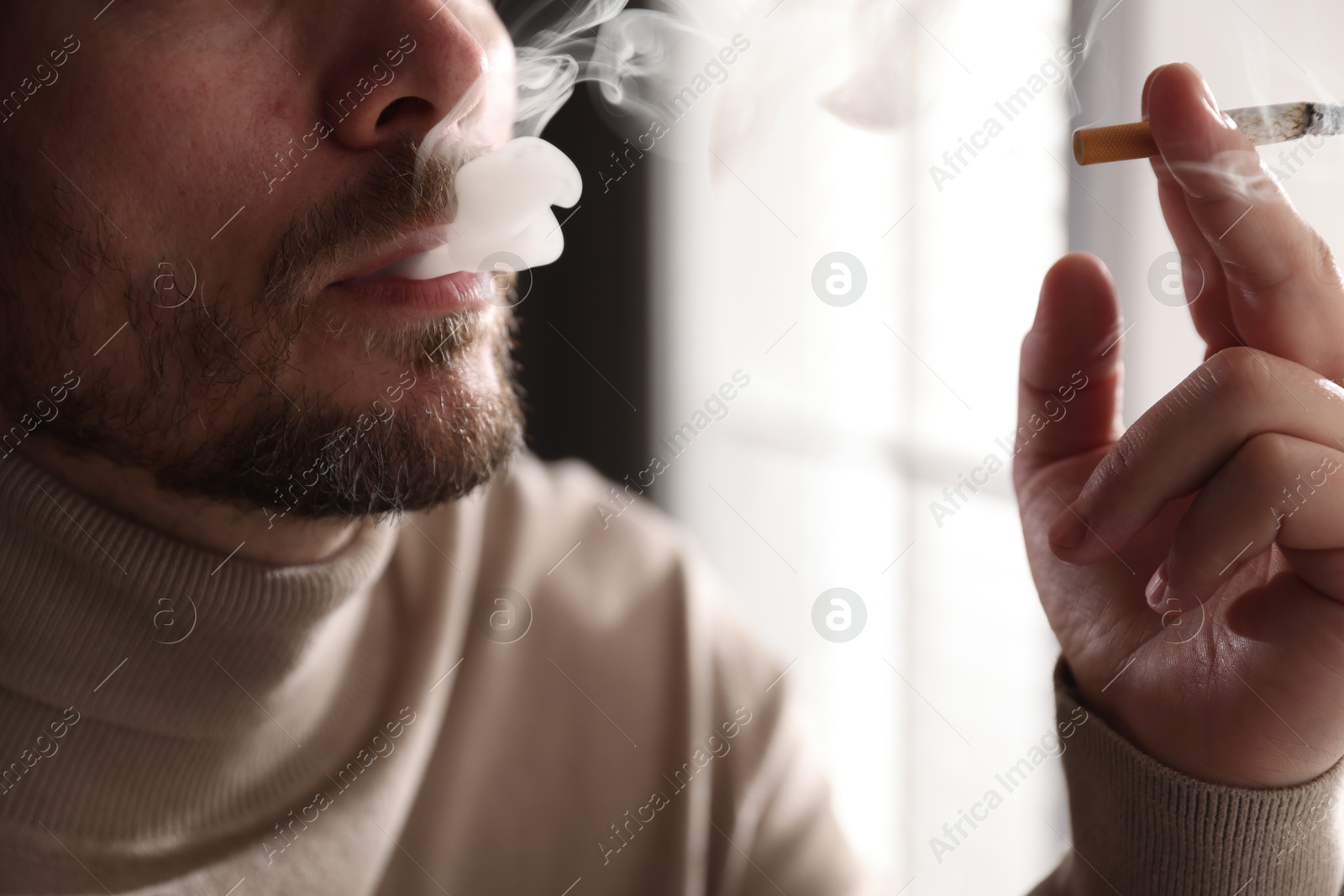 Man smoking cigarette on blurred background, closeup Photo of Man smoking cigarette on blurred background, closeup