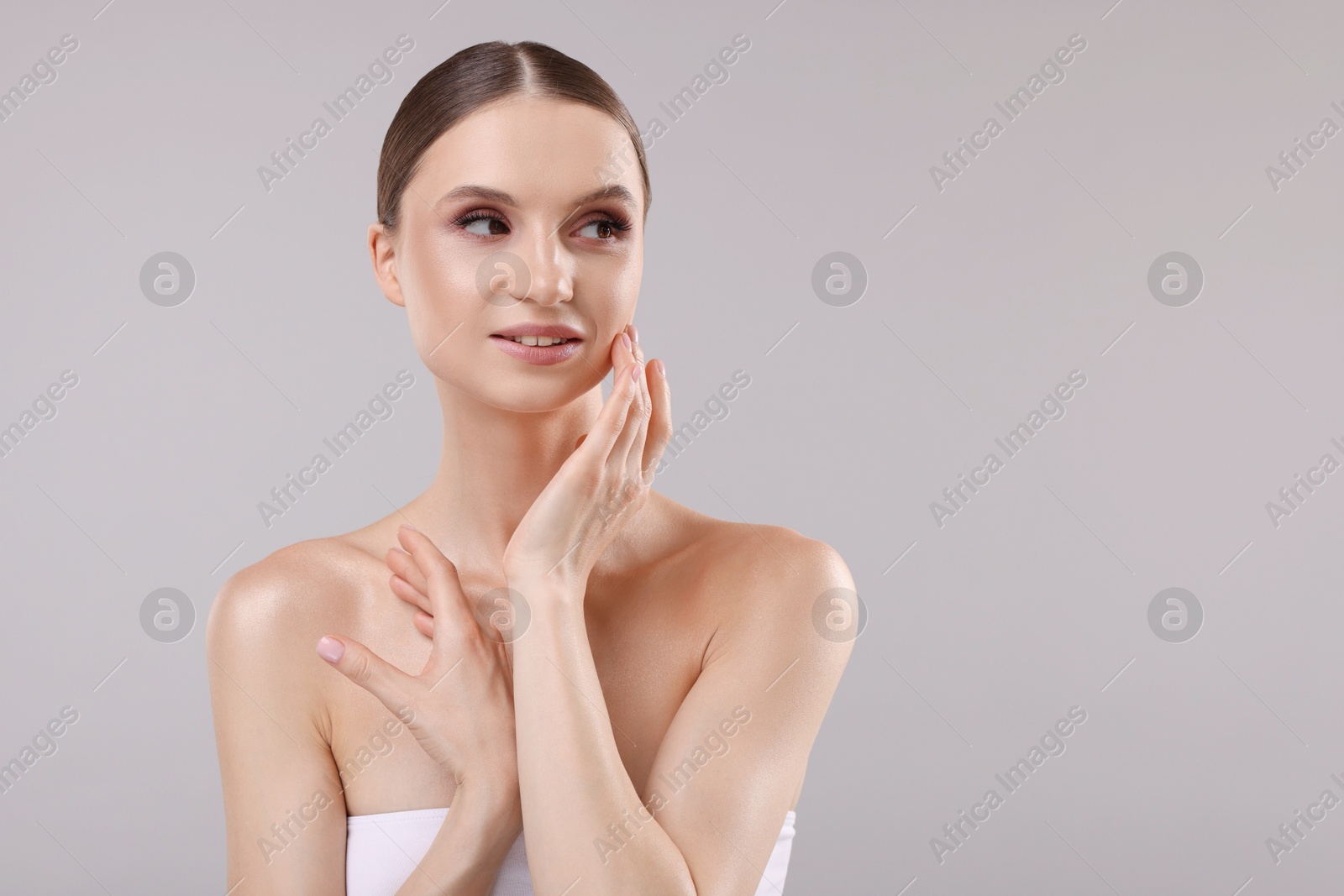 Portrait of beautiful young woman on gray background, space for text Photo of Portrait of beautiful young woman on gray background, space for text