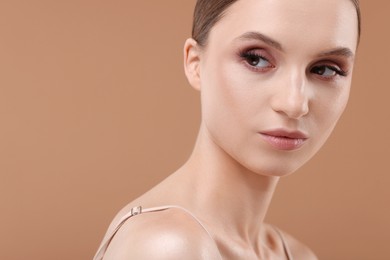 Photo of Portrait of beautiful young woman on beige background, closeup. Space for text