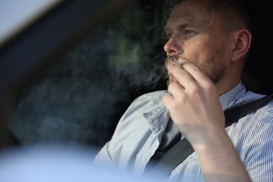 Photo of Man smoking cigarette in car, view from outside
