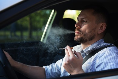 Photo of Man smoking cigarette in car, view from outside