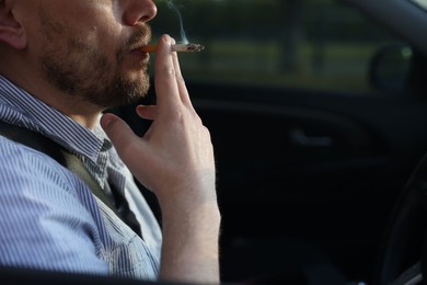 Photo of Man smoking cigarette in car, closeup. Space for text