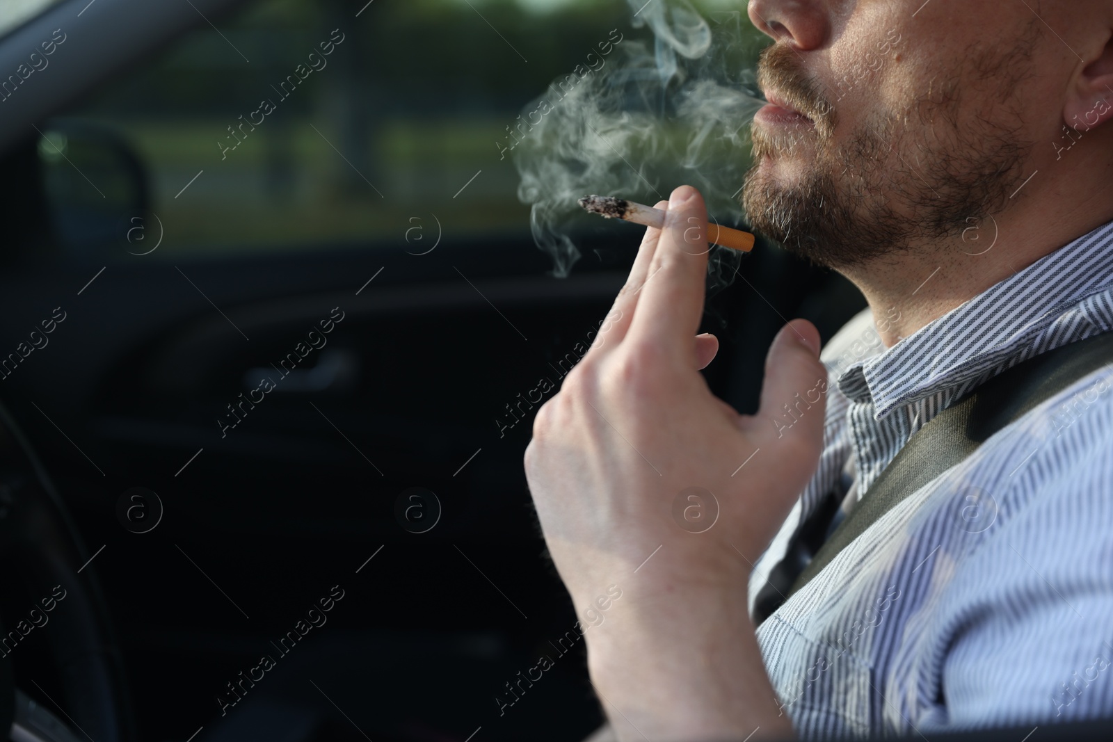 Man smoking cigarette in car, closeup. Space for text Photo of Man smoking cigarette in car, closeup. Space for text
