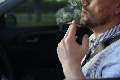 Photo of Man smoking cigarette in car, closeup. Space for text