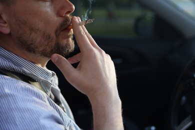 Photo of Man smoking cigarette in car, closeup. Space for text