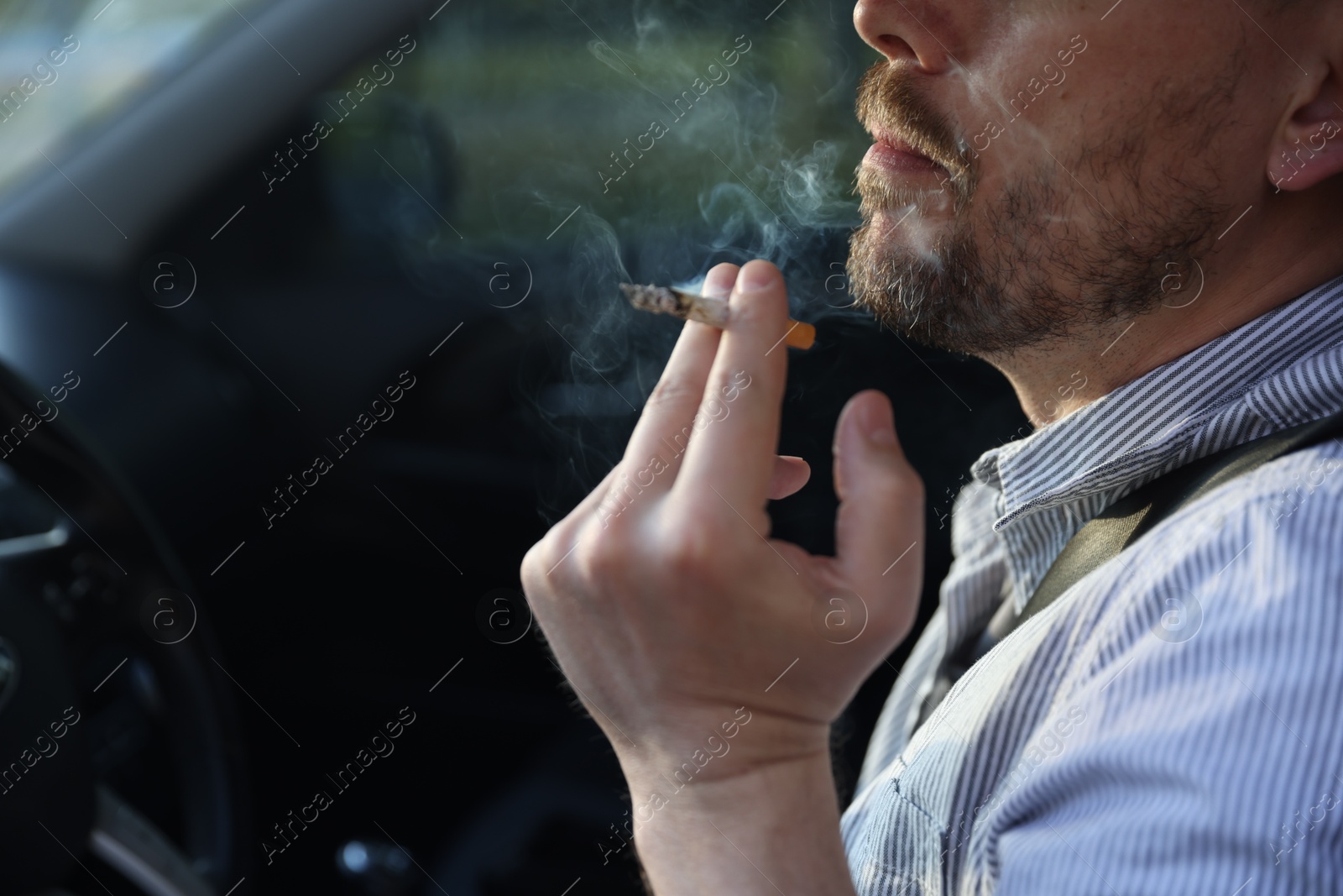 Man smoking cigarette in car, closeup. Space for text Photo of Man smoking cigarette in car, closeup. Space for text
