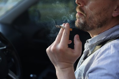 Photo of Man smoking cigarette in car, closeup. Space for text