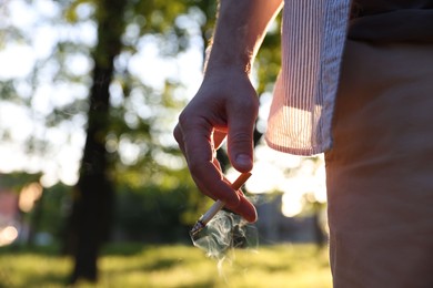 Photo of Man with cigarette in park, closeup. Space for text