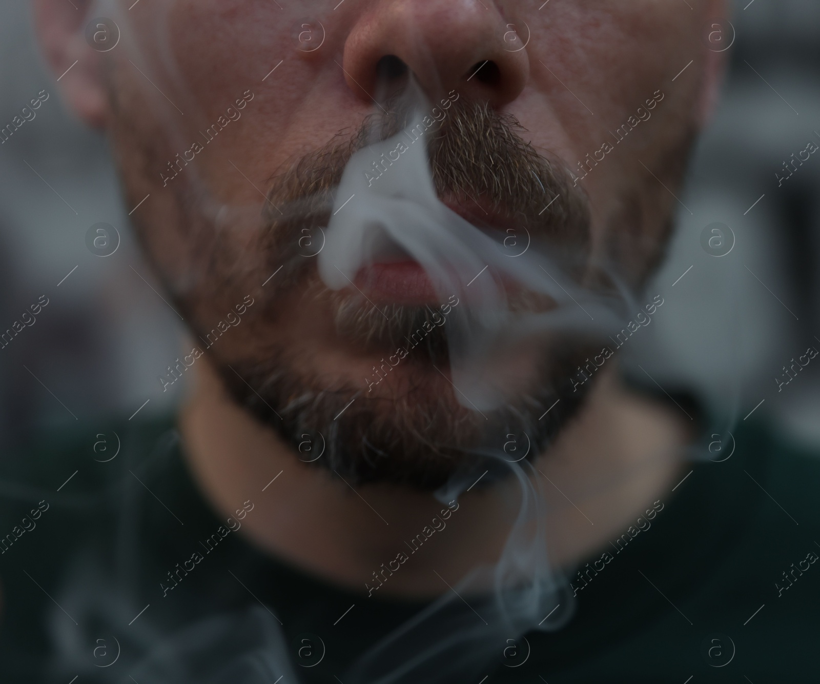 Man smoking cigarette on blurred background, closeup Photo of Man smoking cigarette on blurred background, closeup