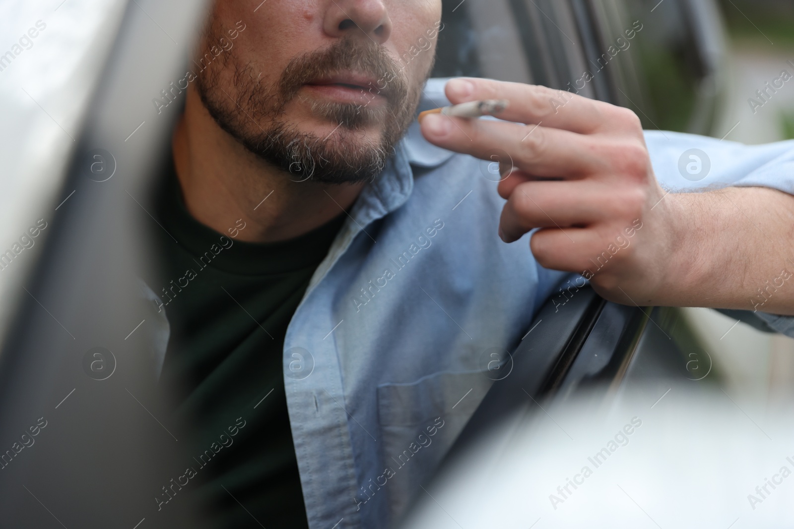 Man smoking cigarette in car, closeup view Photo of Man smoking cigarette in car, closeup view