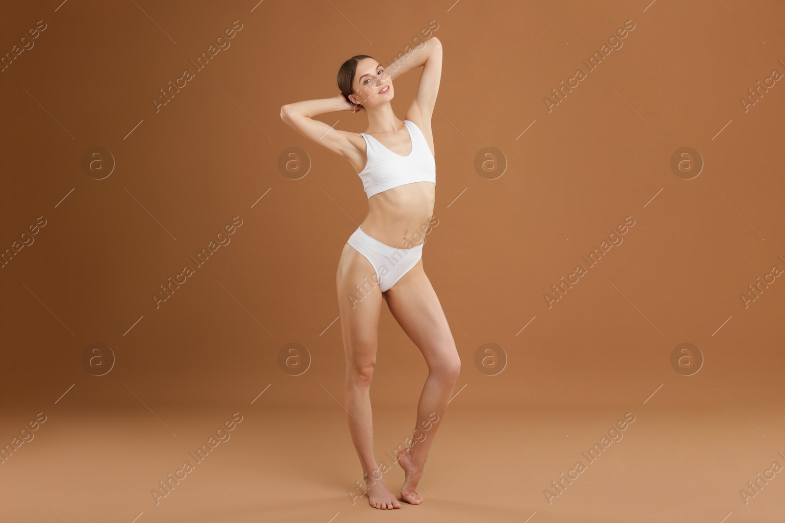 Beautiful woman with perfect slim body on beige background Photo of Beautiful woman with perfect slim body on beige background