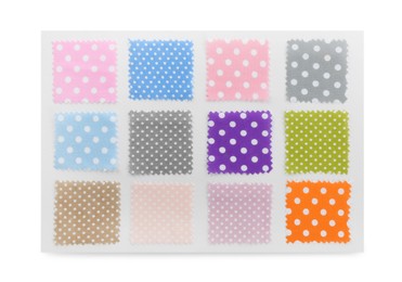 Photo of Samples of fabrics with polka dot pattern isolated on white, top view