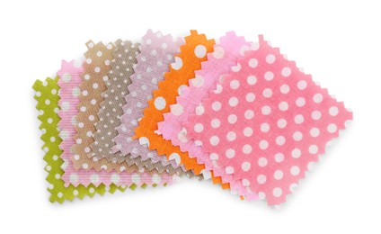 Photo of Samples of fabrics with polka dot pattern isolated on white, top view