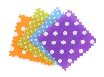 Photo of Samples of fabrics with polka dot pattern isolated on white, top view