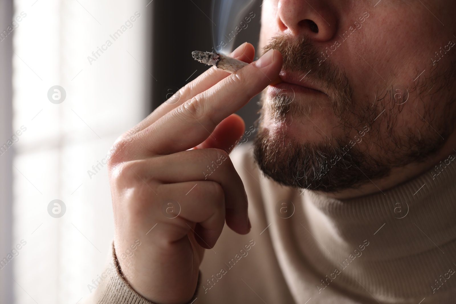 Man smoking cigarette on blurred background, closeup Photo of Man smoking cigarette on blurred background, closeup