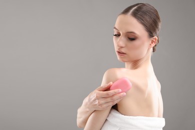 Photo of Beautiful woman with soap bar on grey background. Space for text