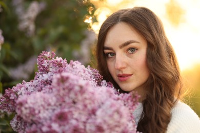 Photo of Portrait of beautiful woman with lilac flowers outdoors in morning