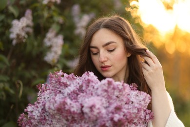 Photo of Portrait of beautiful woman with lilac flowers outdoors in morning