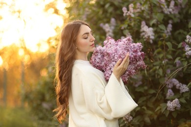 Photo of Beautiful woman with lilac flowers outdoors in morning