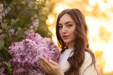 Photo of Portrait of beautiful woman with lilac flowers outdoors in morning