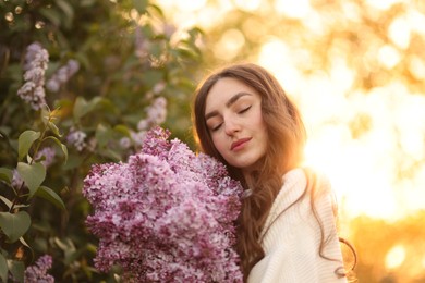Photo of Beautiful woman with bouquet of lilac flowers outdoors in morning