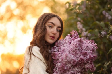 Photo of Portrait of beautiful woman with lilac flowers outdoors in morning
